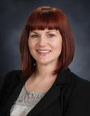 A woman with red hair and a black jacket.