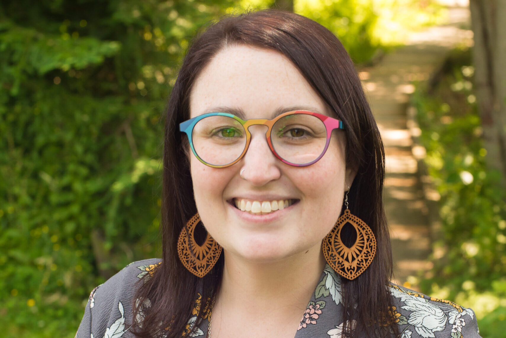 A woman wearing glasses and smiling for the camera.