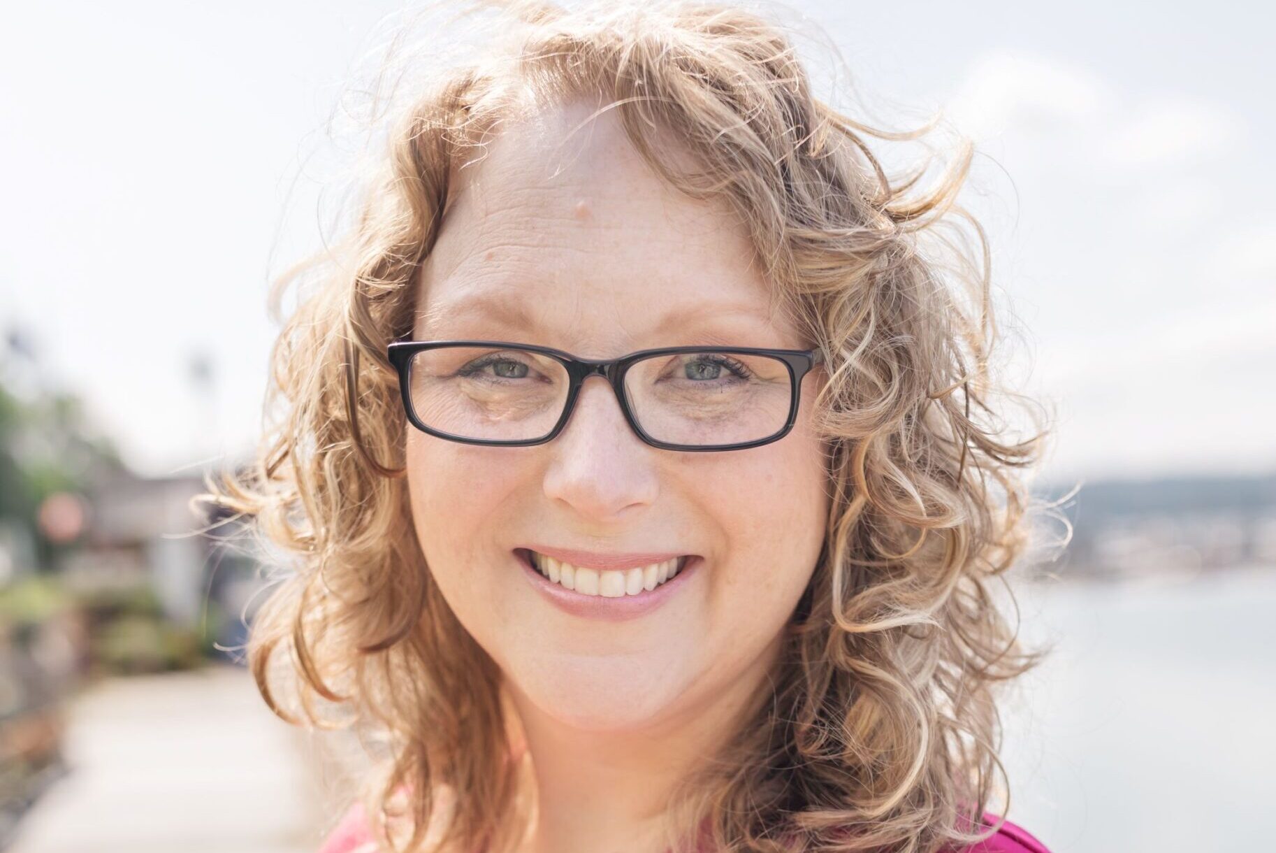 A woman in glasses and a pink shirt
